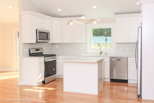 kitchen featuring a kitchen island, light hardwood / wood-style flooring, stainless steel appliances, and white cabinets