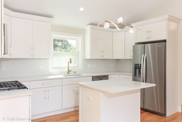 kitchen featuring appliances with stainless steel finishes, a center island, sink, and white cabinets