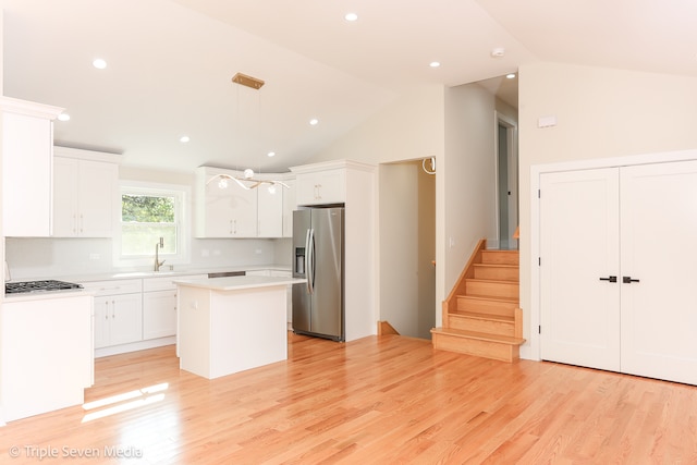 kitchen featuring pendant lighting, a center island, white cabinets, light hardwood / wood-style flooring, and stainless steel appliances