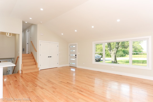 unfurnished living room featuring light wood-type flooring and high vaulted ceiling