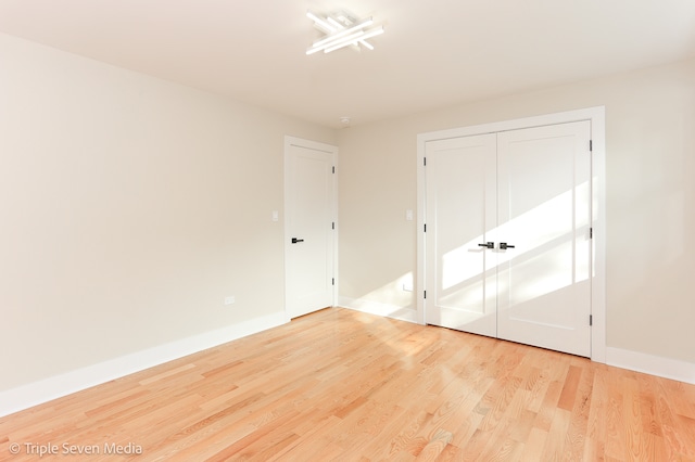 unfurnished bedroom featuring light wood-type flooring and a closet