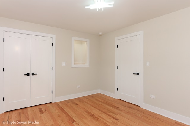 unfurnished bedroom featuring light wood-type flooring and a closet