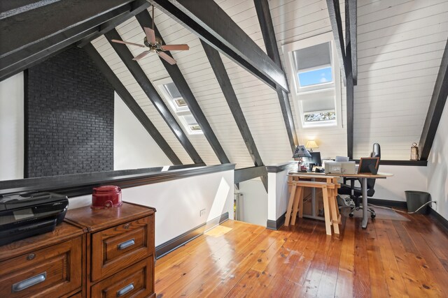 office featuring wood-type flooring, lofted ceiling with skylight, and ceiling fan