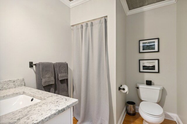 bathroom with ornamental molding, hardwood / wood-style flooring, vanity, and toilet