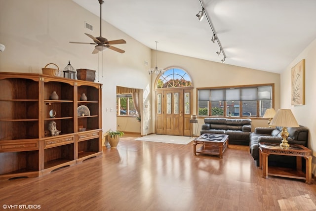 living room with ceiling fan, high vaulted ceiling, light hardwood / wood-style flooring, and track lighting