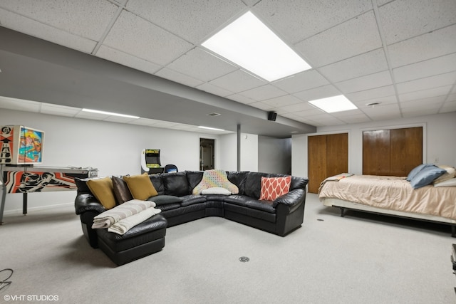 carpeted living room featuring a drop ceiling