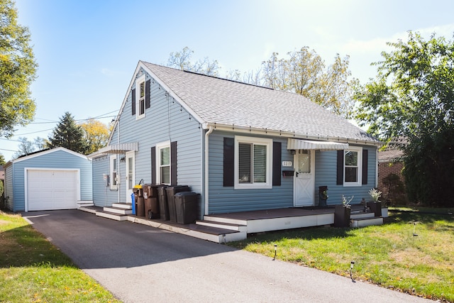 view of front of house featuring a front yard, a garage, a wooden deck, and an outbuilding