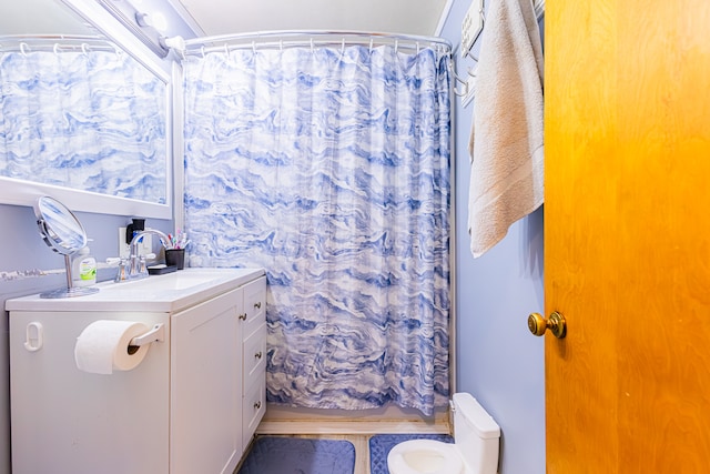 bathroom featuring curtained shower, vanity, and toilet