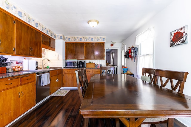 kitchen with appliances with stainless steel finishes, decorative backsplash, dark hardwood / wood-style flooring, and sink