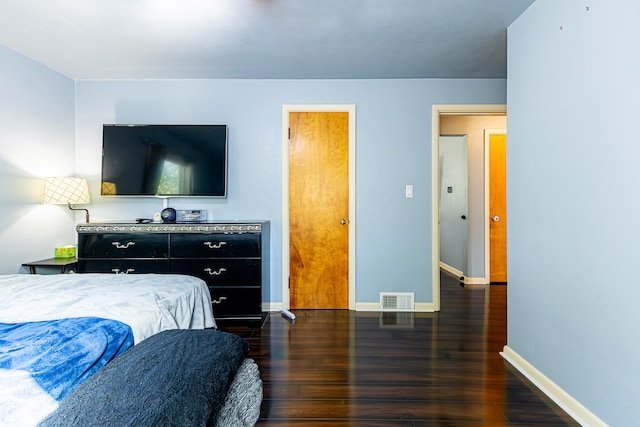 bedroom with dark hardwood / wood-style flooring