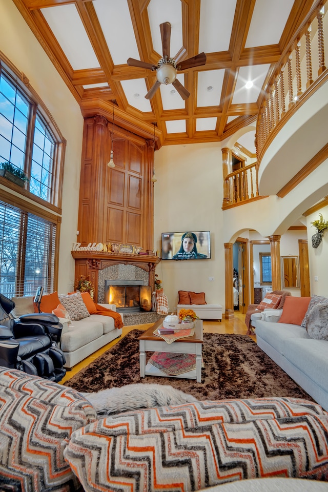 living room with ornamental molding, beam ceiling, a premium fireplace, coffered ceiling, and decorative columns