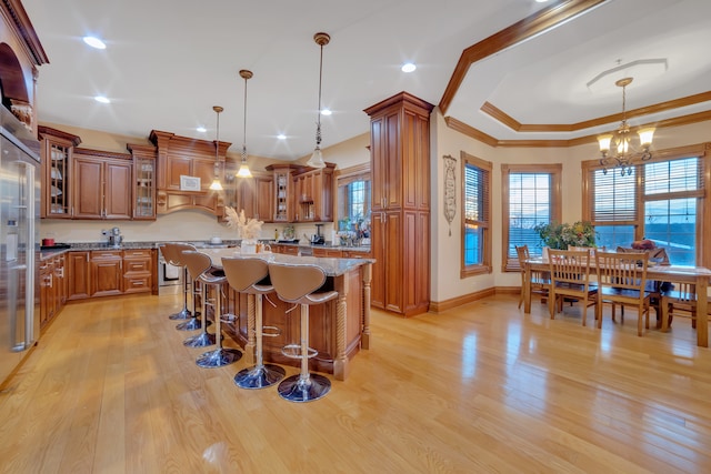 kitchen with decorative light fixtures, light wood-type flooring, and a kitchen island