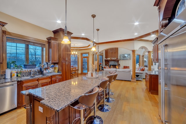 kitchen featuring pendant lighting, a center island, sink, a kitchen breakfast bar, and stainless steel appliances