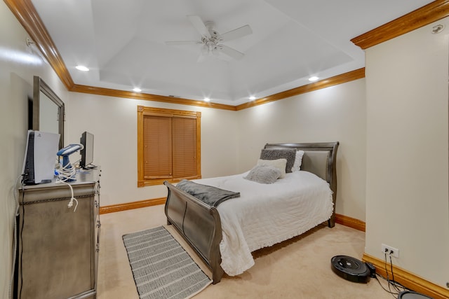 carpeted bedroom with ceiling fan, a tray ceiling, and ornamental molding