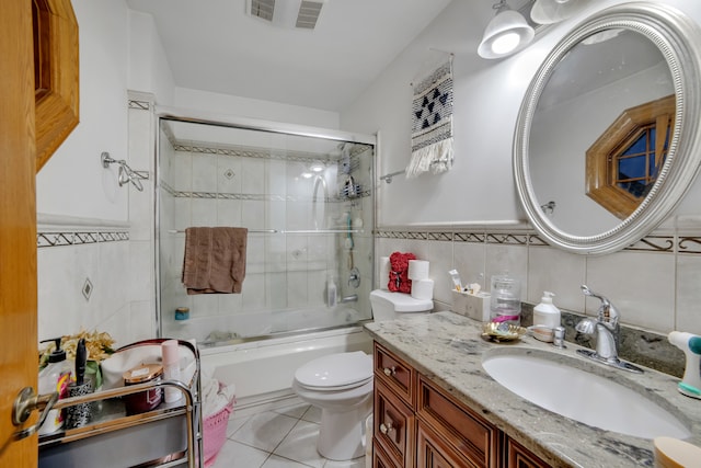 full bathroom with tile walls, vanity, enclosed tub / shower combo, toilet, and tile patterned floors