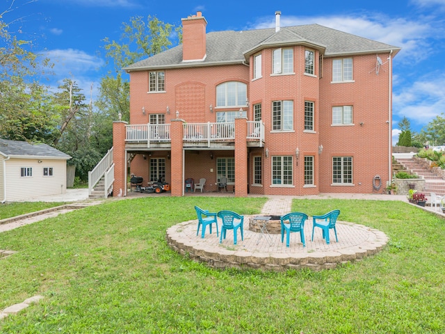 rear view of house with a deck, a yard, a patio, and an outdoor fire pit