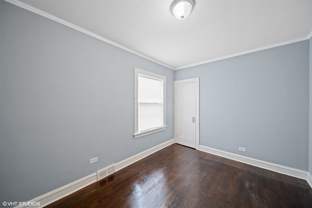 empty room featuring ornamental molding and dark hardwood / wood-style flooring