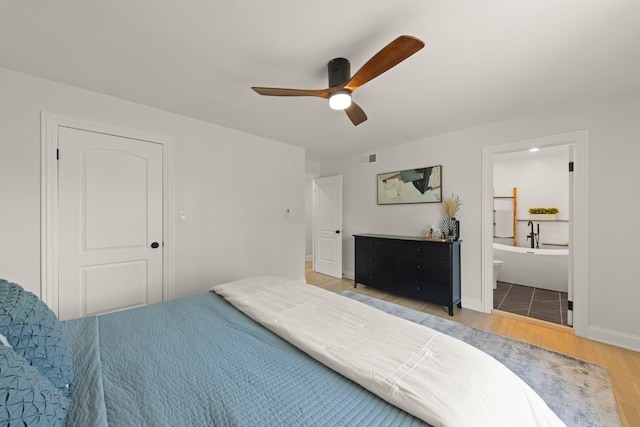 bedroom with wood-type flooring, connected bathroom, and ceiling fan