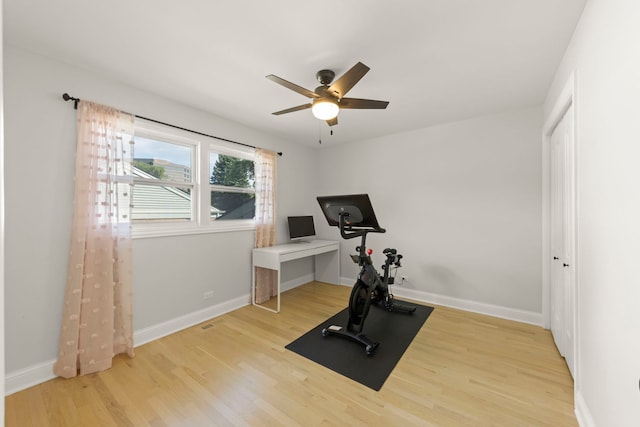 exercise room with light hardwood / wood-style flooring and ceiling fan