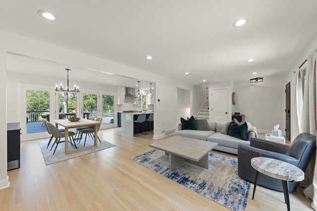 living room with a chandelier and light hardwood / wood-style floors