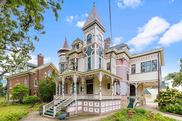 victorian-style house featuring covered porch and a garage