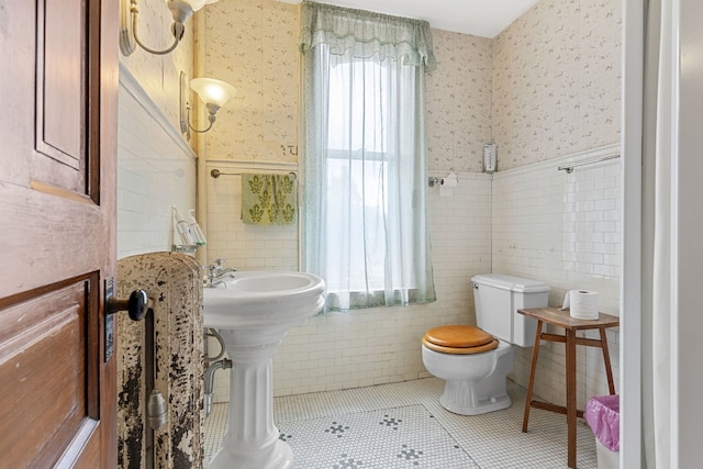 bathroom with tile walls, tile patterned flooring, and toilet