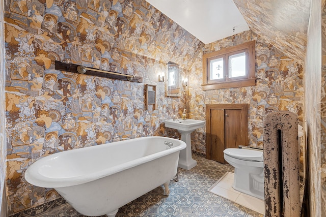 bathroom with vaulted ceiling, sink, toilet, and a bath