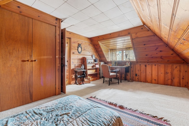 carpeted bedroom with lofted ceiling and wood walls