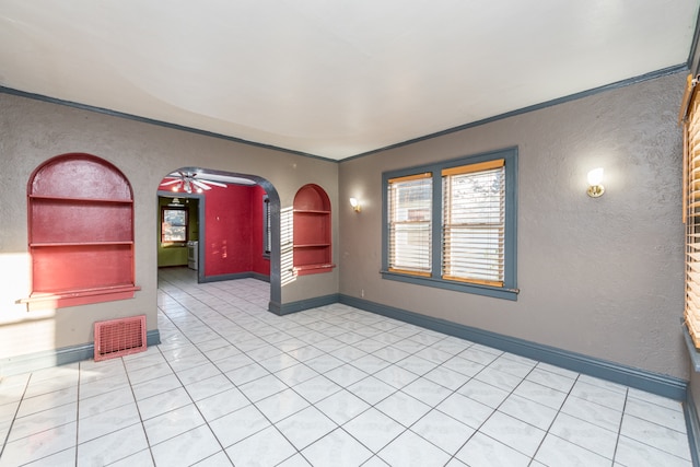 tiled spare room featuring ornamental molding