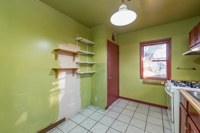 kitchen with hanging light fixtures, white gas stove, and light tile patterned floors