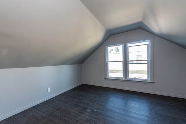 additional living space featuring dark hardwood / wood-style floors and lofted ceiling