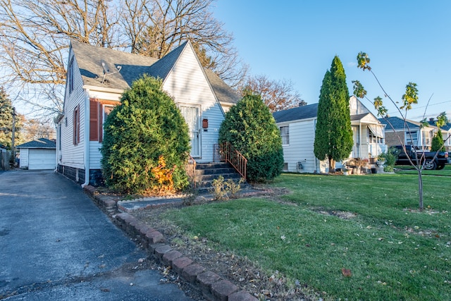 view of front of house with an outbuilding, a garage, and a front yard