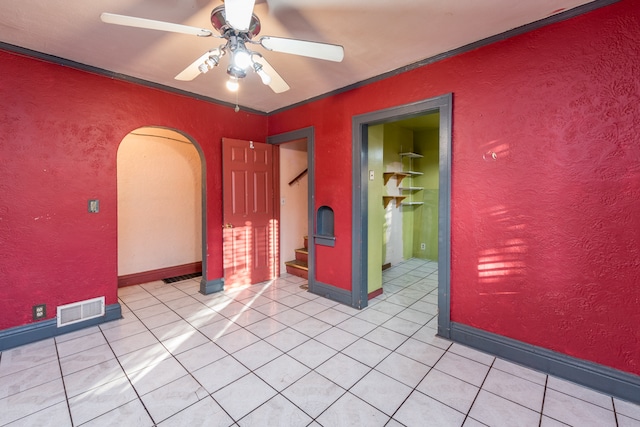 unfurnished room with ornamental molding, ceiling fan, and light tile patterned floors