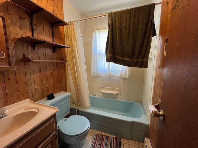 full bathroom featuring wooden walls, vanity, toilet, and shower / tub combo