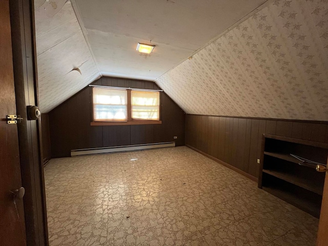 bonus room featuring a baseboard radiator, wooden walls, and vaulted ceiling