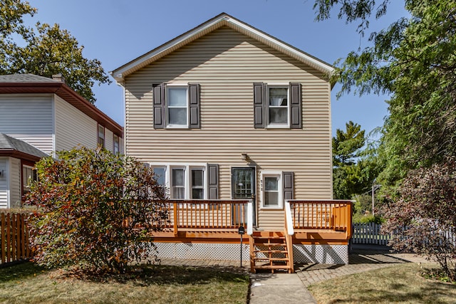 rear view of house featuring a lawn and a deck