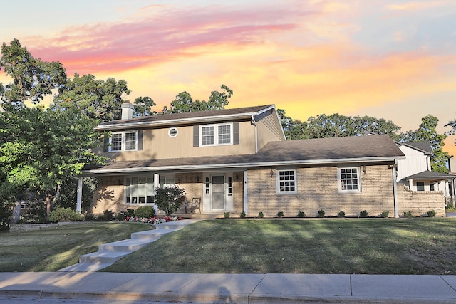 view of front of house with a yard and a porch