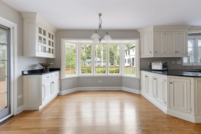 kitchen featuring hanging light fixtures, light hardwood / wood-style flooring, and a wealth of natural light