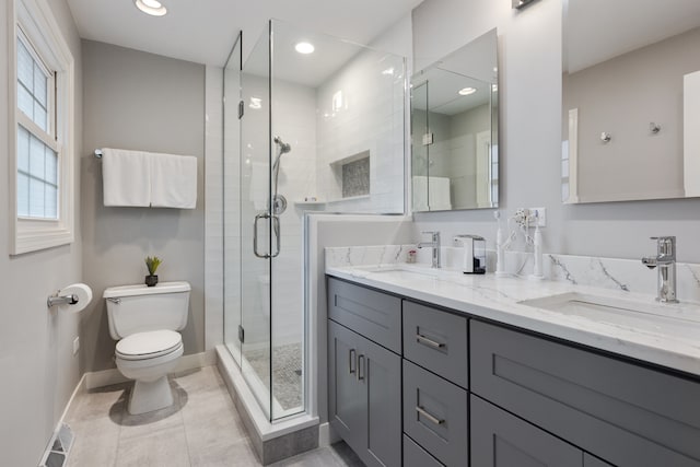 bathroom with tile patterned flooring, walk in shower, vanity, and toilet