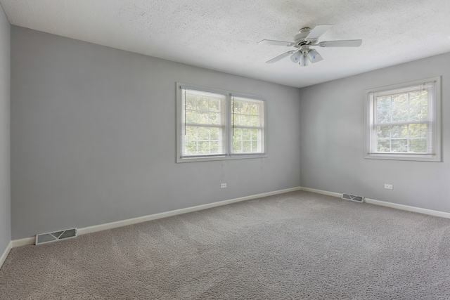 empty room featuring carpet floors, ceiling fan, and a wealth of natural light