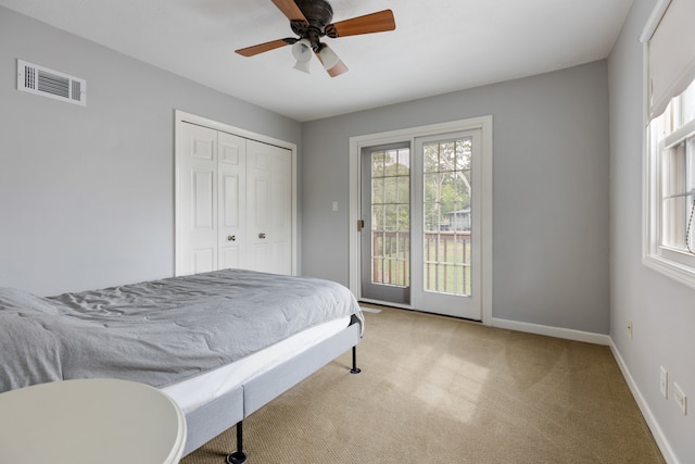 carpeted bedroom with ceiling fan, a closet, and access to exterior