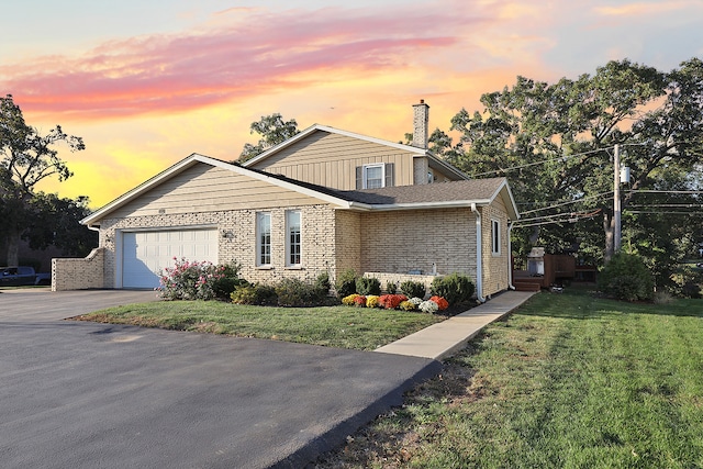 view of front of home featuring a garage and a lawn