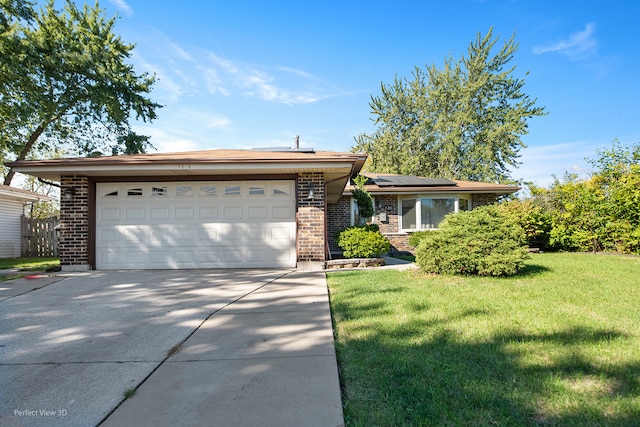 ranch-style home featuring solar panels, a garage, and a front lawn