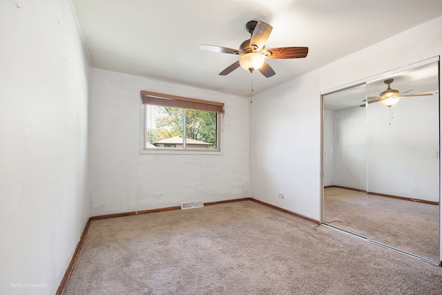 unfurnished bedroom with ceiling fan, a closet, and light colored carpet