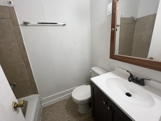 full bathroom featuring tiled shower / bath, vanity, and toilet