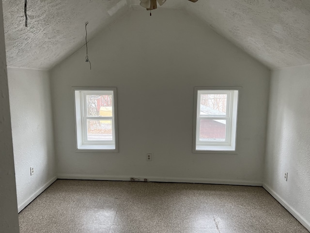 bonus room with lofted ceiling, a textured ceiling, and ceiling fan