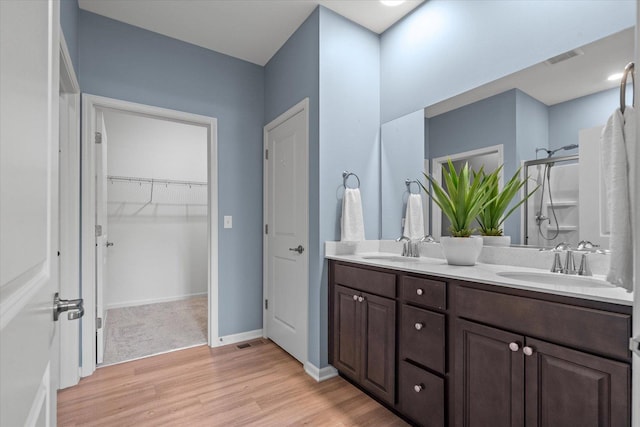 25556 W Springview Dr, Plainfield, IL 60586 - bathroom with wood finished floors, double vanity, a shower stall, and a walk in closet