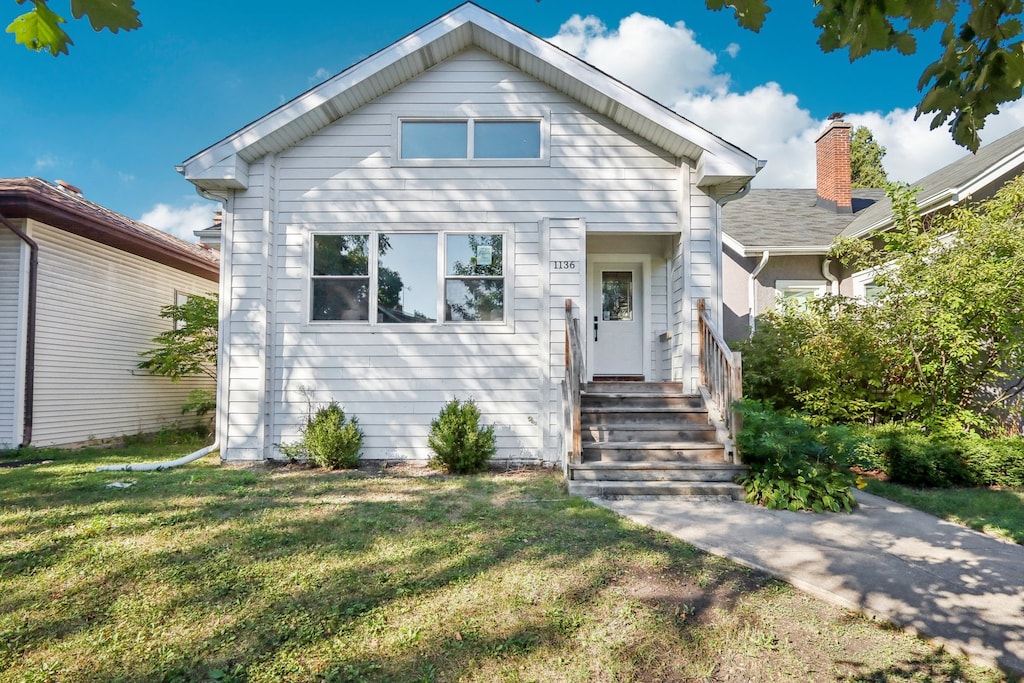 bungalow-style home with a front yard