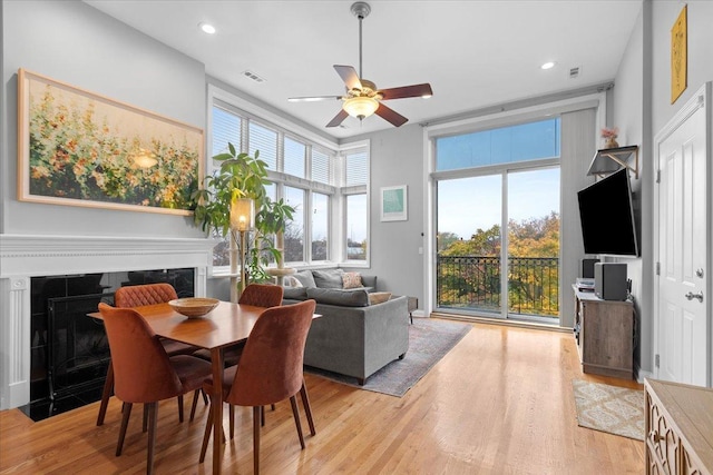 dining room featuring ceiling fan, a healthy amount of sunlight, and light hardwood / wood-style floors