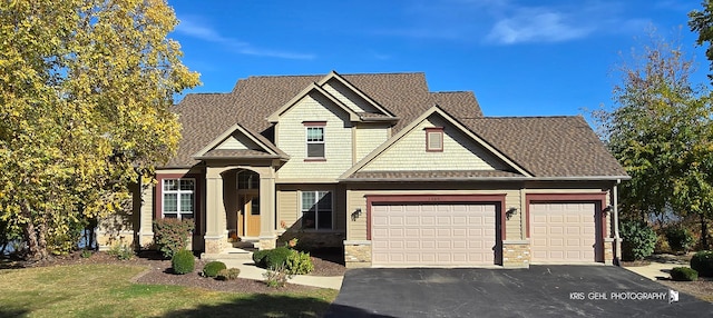 craftsman inspired home featuring stone siding, aphalt driveway, and an attached garage